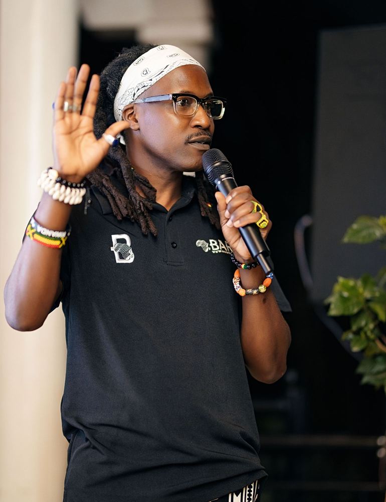 A speaker in a BARA polo shirt talks into a microphone at Event One