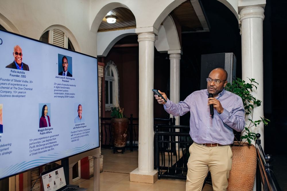 A presenter points to slides on a screen under the arches at Kreyol Fusion
