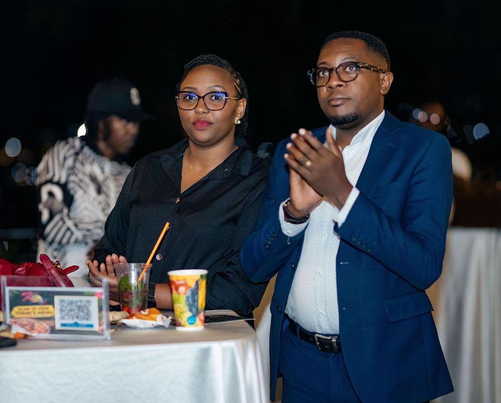 Two guests at a standing table applaud a presentation